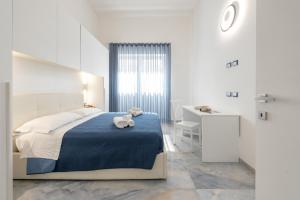 a white bedroom with a bed and a desk at ALG Apartments con Parcheggio in Porto Cesareo