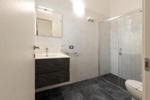 a white bathroom with a sink and a shower at ALG Apartments in Porto Cesareo +44 photos