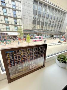 Una estantería en una ventana con vistas a una ciudad. en Central Sheffield 1 Bed Flat, Sleeps 3, City Views, Full Kitchen, en Midland