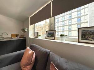 Una sala de estar con un sofá y una ventana. en Central Sheffield 1 Bed Flat, Sleeps 3, City Views, Full Kitchen, en Midland