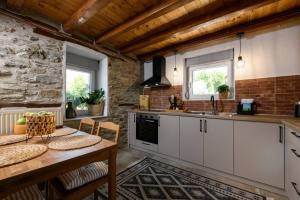 a kitchen with white cabinets and a table at Toutounis House Kazaviti in Mikros Prinos