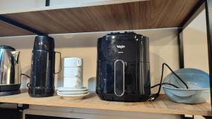 a black blender sitting on top of a shelf at Studio 4 novo completo com wi-fi e estacionamento in Curitiba
