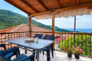 a table and chairs on a balcony with a view of the ocean at Christina's Village Home in Kallirakhi