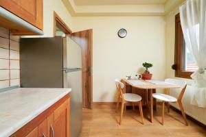 a kitchen with a table and a refrigerator at Christina's Village Home in Kallirakhi