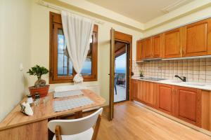 a kitchen with wooden cabinets and a table at Christina's Village Home in Kallirakhi +15 photos