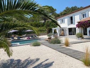 a house with a swimming pool and a palm tree at Villa Oliandre in Plan-de-la-Tour
