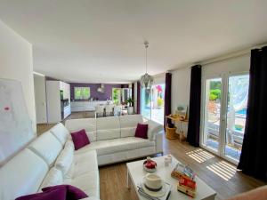 a living room with a white couch and a table at Villa Oliandre in Plan-de-la-Tour +9 photos