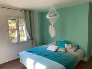 a bedroom with a blue bed with a dreaming sign on the wall at Villa Oliandre in Plan-de-la-Tour