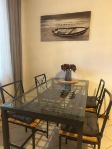 a glass dining room table with chairs and a vase with flowers at Casa Ulla - in direkter Seelage - fantastischer Ausblick in Gravedona +32 photos