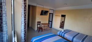 a bedroom with a bed and a table and a chair at HOSPEDAJE Valeria TM in Tingo María