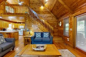 a living room with two blue couches and a staircase at Lucilles Creekside Hideaway in Blue Ridge