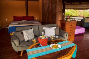 a living room with a couch and a bed at Hotel Restaurante Mi Jardin Troncones in Troncones