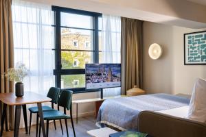 ein Hotelzimmer mit einem Bett, einem Schreibtisch und einem Fenster in der Unterkunft Yuna Montmartre - ApartHotel in Paris + 37 Fotos