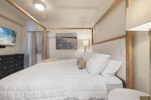 Un dormitorio con una gran cama blanca en una habitación. en Sea Glass 402 by Liquid Life, en Gulf Shores 19 fotos más