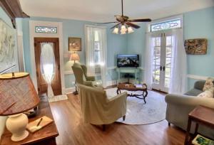 a living room with blue walls and a ceiling fan at Cricket Cottage in Eureka Springs