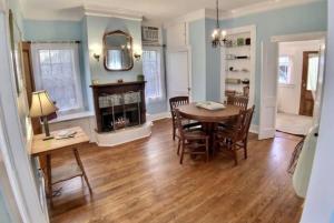 a dining room with a table and chairs and a fireplace at Cricket Cottage in Eureka Springs