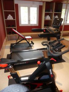 a gym with two exercise bikes and a treadmill at Brit Hotel Confort Alençon in Alençon
