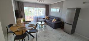 cocina y sala de estar con mesa y nevera en Modern apartment in Golf del Sur, AC237, tempered pool and ocean view, en San Miguel de Abona