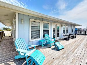 a deck with blue chairs and tables on a house at Bets Kept Secret in Fort Morgan