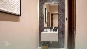 a bathroom with a sink and a mirror at نزل سدن in Quai +17 photos