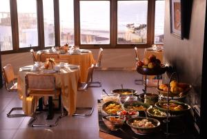ein Esszimmer mit einem Tisch und Teller mit Lebensmitteln in der Unterkunft Hosteria Tequendama Classic & Resort in Villa Gesell