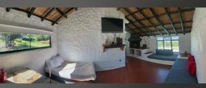 un soggiorno con un divano e una TV di Cabaña La Santa María a Guatavita