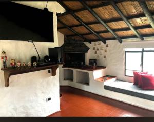 un soggiorno con TV a schermo piatto e camino di Cabaña La Santa María a Guatavita