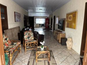 a living room with a couch and chairs and a table at Casa Brisa do Mar in Pontal do Paraná