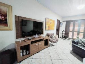 a living room with a large flat screen tv at Casa Brisa do Mar in Pontal do Paraná