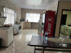 a kitchen with a refrigerator and a table in it at Casa Brisa do Mar in Pontal do Paraná