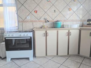 a kitchen with white cabinets and a stove top oven at Casa Brisa do Mar in Pontal do Paraná +51 photos