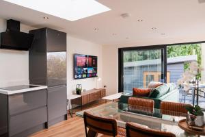 a kitchen and living room with a glass table at Luxury Apartment nr Broadway with Private Parking! in Evesham