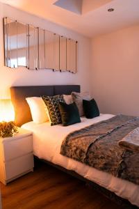 a bedroom with a bed with pillows on it at Luxury Apartment nr Broadway with Private Parking! in Evesham