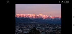 a view of a snow covered mountain with a city at Dimora 99 in LʼAquila