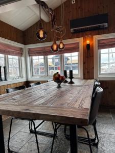 un grande tavolo in legno in una stanza con finestre di Guest favorite - 3 BR Mountain Lodge near Vøringsfossen a Maurset Altre 17 foto