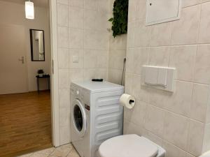 a bathroom with a washing machine and a toilet at Gassenzauber in Pirna +11 photos