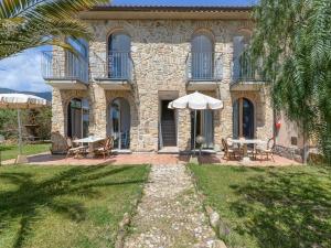 a stone house with tables and chairs in front of it at Appartamenti dolores castle in Marina di Campo Airport