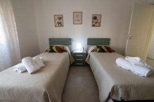 2 camas individuales en un dormitorio con luz en Zìchè house, en Gallipoli