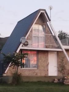 a house with a metal roof and a balcony at Cabañas Jazmines del Lago in San Roque