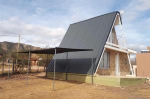 a small house with a black roof on top of it at Cabañas Jazmines del Lago in San Roque +13 photos