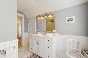 a white bathroom with a sink and a mirror at Quaint Bungalow in Kennebunk +53 photos