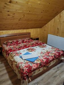 a bed with a book on it in a room at Casute ,, la dani" in Corbu