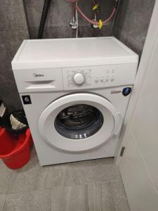 a white washing machine sitting in a room at Grand Marina Apartments Batumi in Batumi