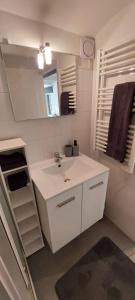 Un baño blanco con lavabo y espejo. en Studio Nice centre, en Niza