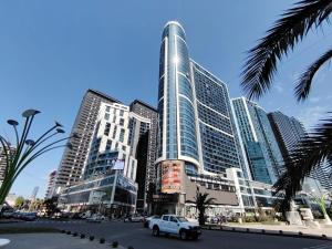 a city with tall buildings and a car on a street at Grand Marina Apartments Batumi in Batumi
