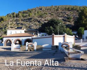 a white building with a mountain in the background at Cozy Townhouse in Algodonales