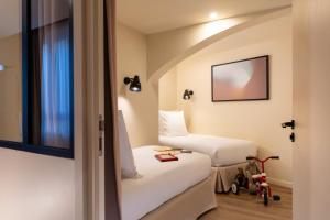 Ein Bett oder Betten in einem Zimmer der Unterkunft Yuna Montmartre - ApartHotel