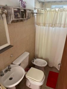 a bathroom with a white toilet and a sink at La Casita in San Antonio de Areco