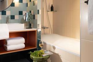 ein Badezimmer mit Dusche und einem Glas Wein in der Unterkunft Yuna Montmartre - ApartHotel in Paris