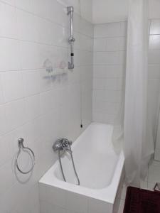 a white bath tub with a shower curtain in a bathroom at uno spazio luminoso e tranquillo vicino Milano in San Zenone al Lambro